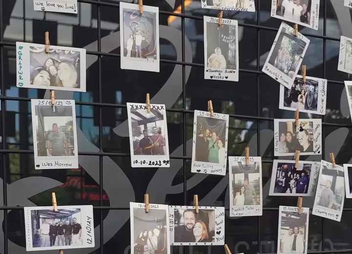 A wall of pinned instant photographs of patients with the team at our clinic