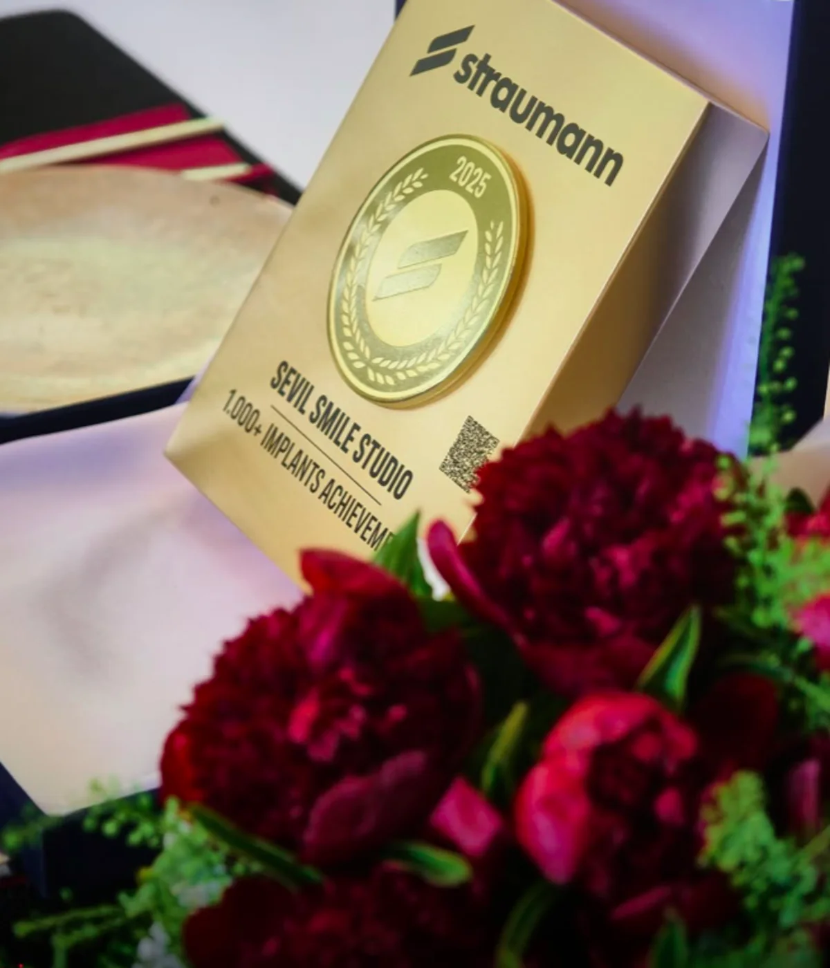 A Straumann implant system box at the Sevil Smile Clinic, with a plaque marking 1,000+ implants placed